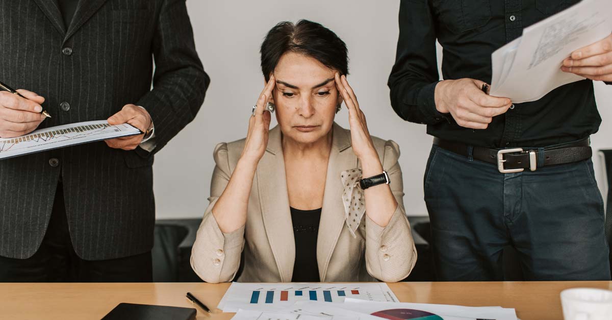 Dirigeante en pleine réflexion entouré de ses équipes