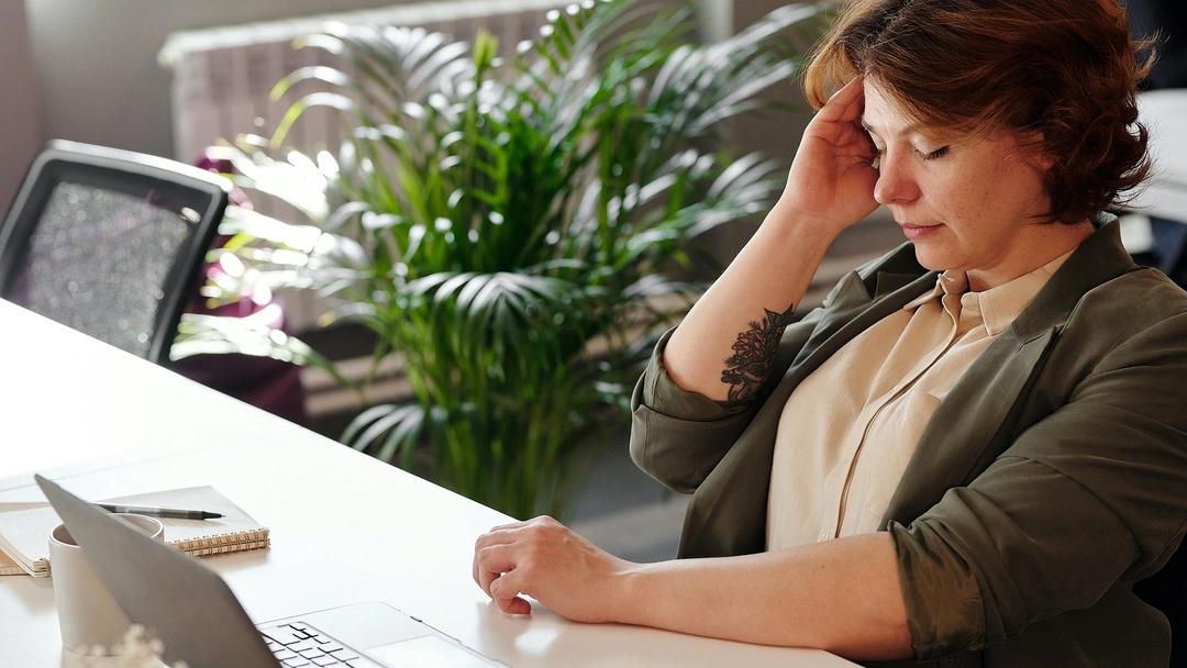 Femme à son poste qui se tient la tête